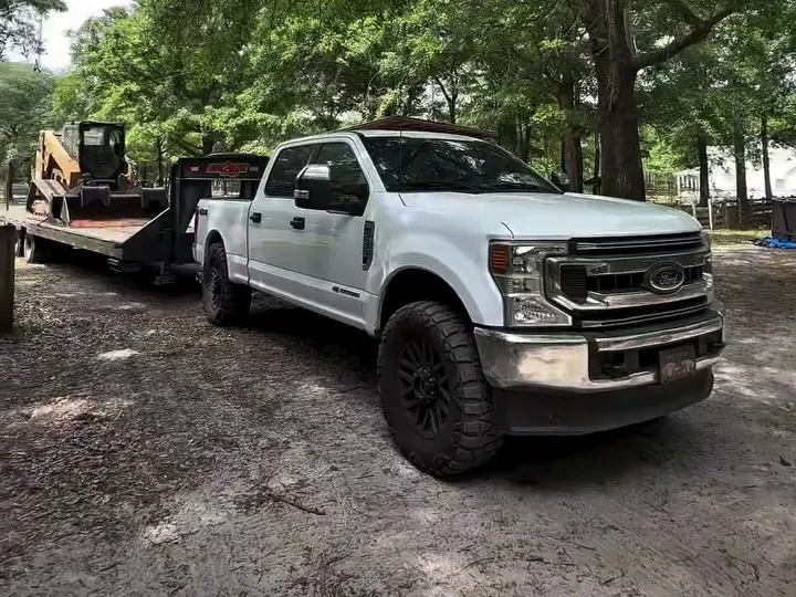 Truck and equipment trailer staged on a graded drive